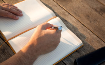 man-writing-in-notebook